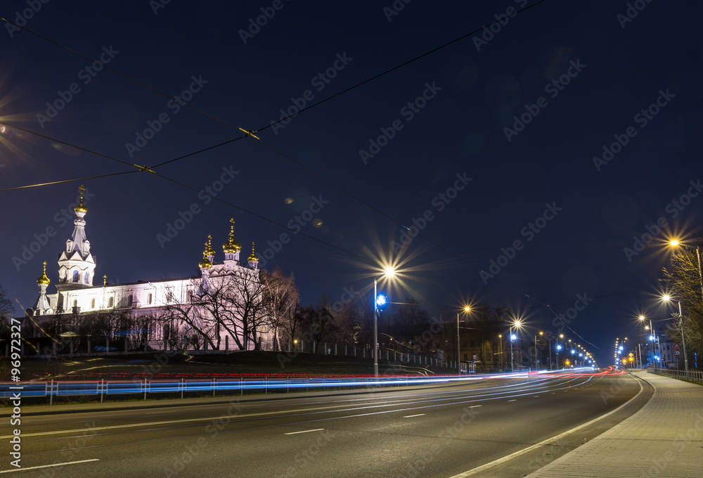 Fototapeta premium View of the night city with tram tracks and church