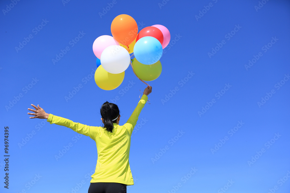 cheering young woman with colorful balloons cheering young woman with colorful balloons