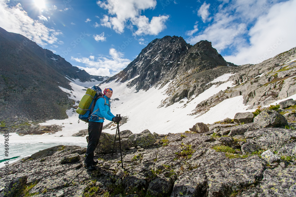 Young woman is hiking in highlands of Altai mountains, Russia