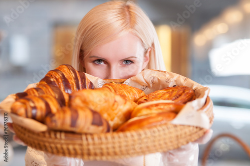 Beautiful blond saleswoman is working at bakery