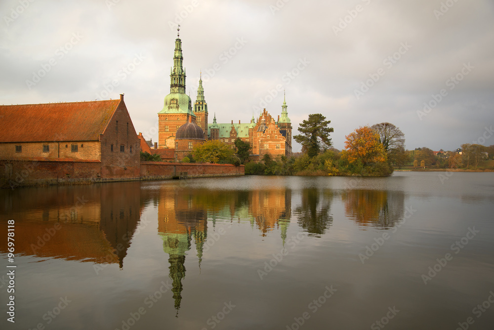 Замок Фредериксборг на осеннем озере пасмурным днем. Дания