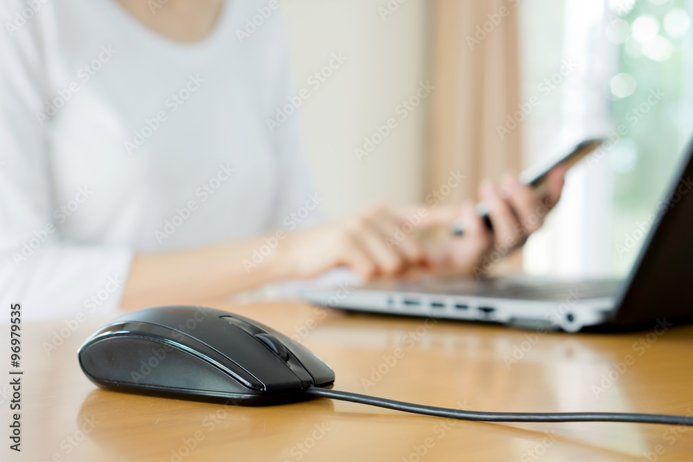 busy young woman is typing on laptop computer and using mobile p busy young woman is typing on laptop computer and using mobile p