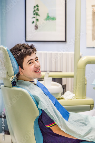 boy on the dentist chair showing braces