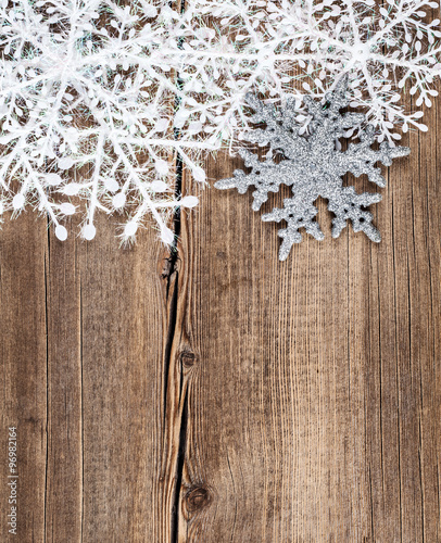 Christmas background. Snowflakes border on grunge wooden board.