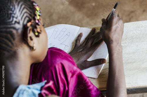 Behind the Shoulders Picture of African Schoolgirl Drawing at School
