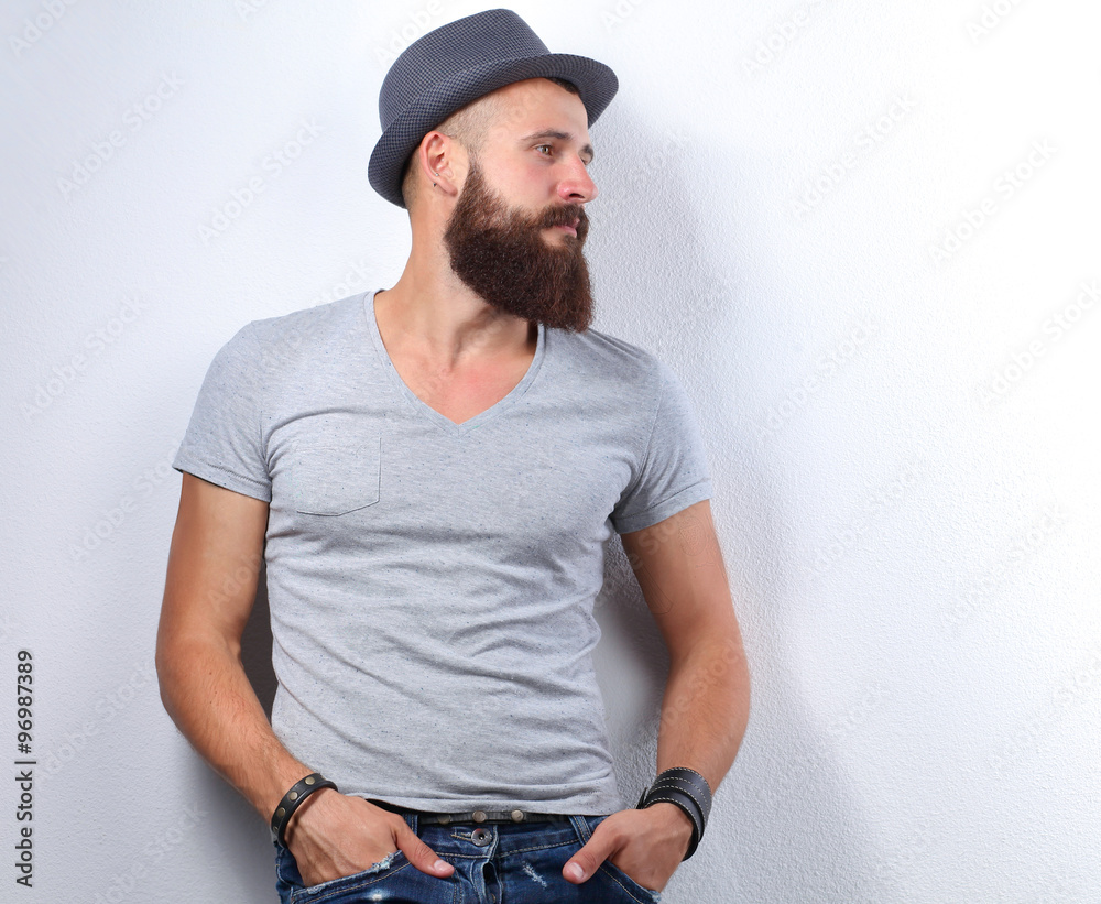 Portrait of handsome bearded man in hat standing , isolated on grey background Portrait of handsome bearded man in hat standing , isolated on grey background