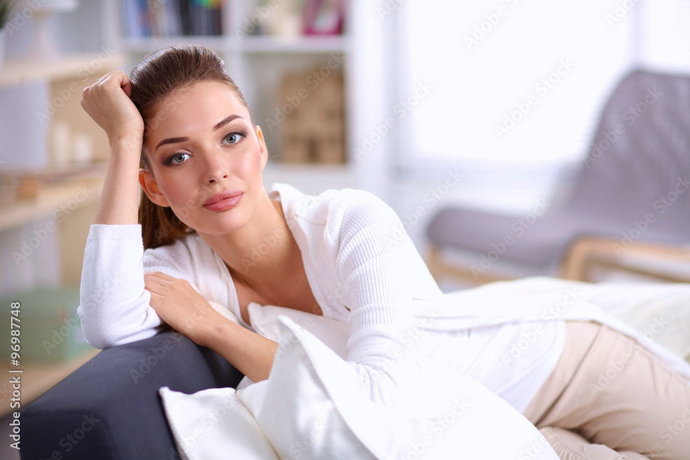 Young beautiful woman sitting on couch at her room Young beautiful woman sitting on couch at her room