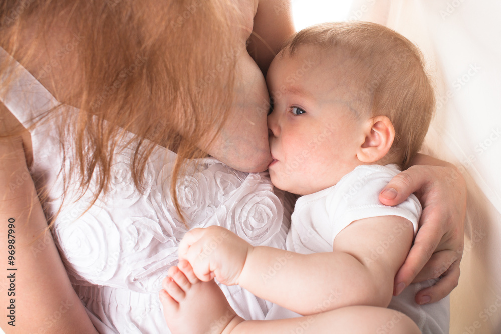 Mom feeds the baby breast, light background Mom feeds the baby breast, light background