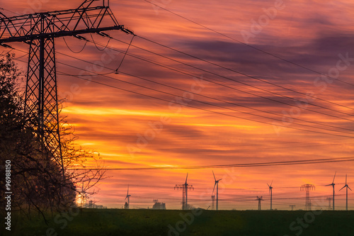 Strommast und Windkrafträder am Abend photo