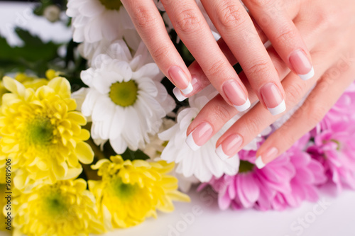 Women's hands on the background of flowers.