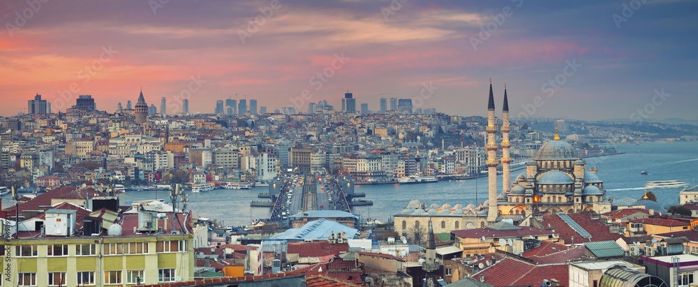 Istanbul Panorama. Panoramic image of Istanbul with Yeni Cami Mosque and Galata Bridge during sunset.