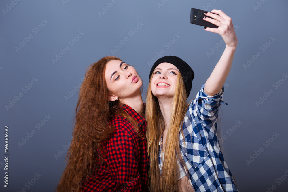 Two young women taking selfie with mobile phone Two young women taking selfie with mobile phone
