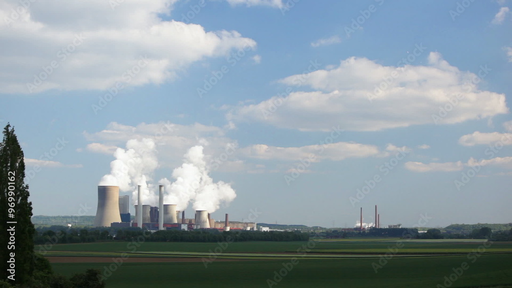 Timelapse sequence of a large steaming coal-fired power station in in the distance with the sunlight being just on the power plant. Timelapse sequence of a large steaming coal-fired power station in in the distance with the sunlight being just on the power plant.