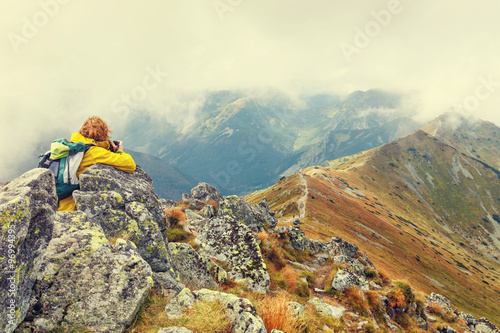 Fototapeta Naklejka Na Ścianę i Meble -  Female photographer shooting a mountain scenery