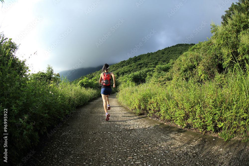 young fitness woman runner running on mountain trail