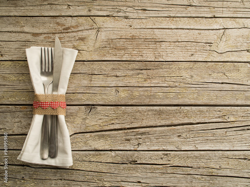 Cutlery kitchenware on old wooden boards background