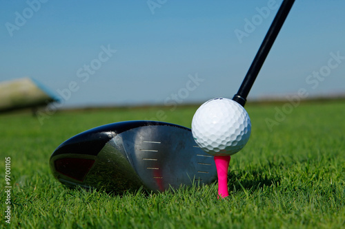 Golf club and ball in grass