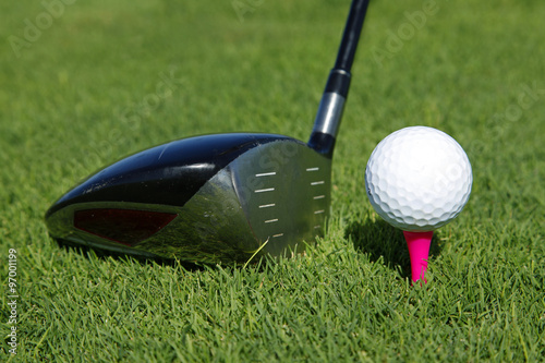 Golf club and ball in grass