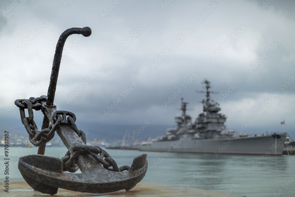 Φωτογραφία Anchor on the embankment and the cruiser in the port of Novoross
