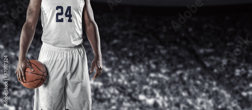 Close up view of Basketball Player in a large basketball arena. Wide angle photo with lots of copy space. © Brocreative
