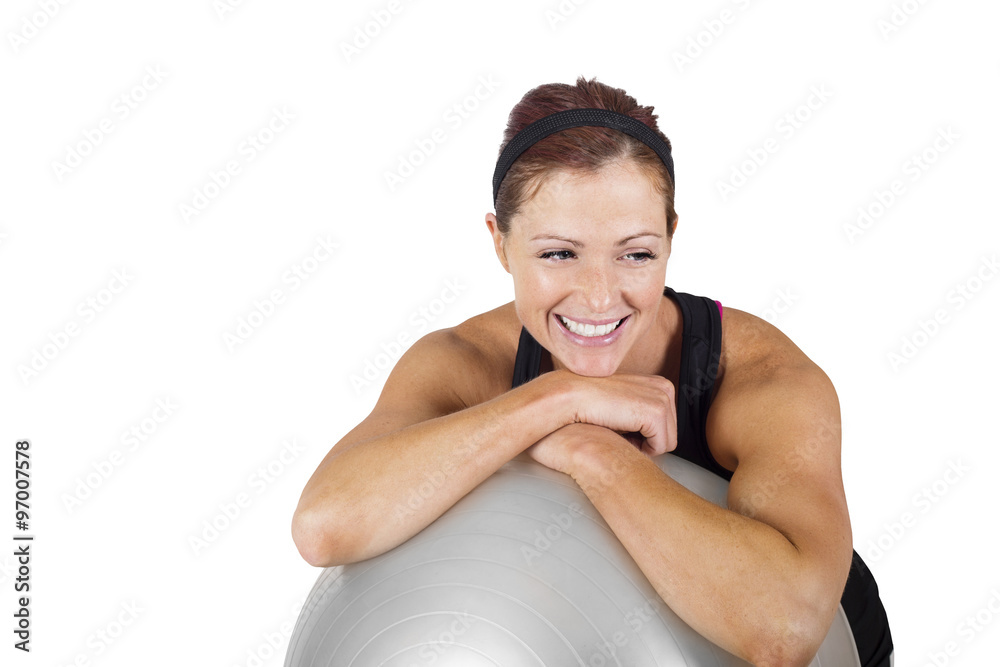 Happy healthy fitness woman resting on a exercise ball. Candid portrait of a smiling woman resting after exercising Happy healthy fitness woman resting on a exercise ball. Candid portrait of a smiling woman resting after exercising