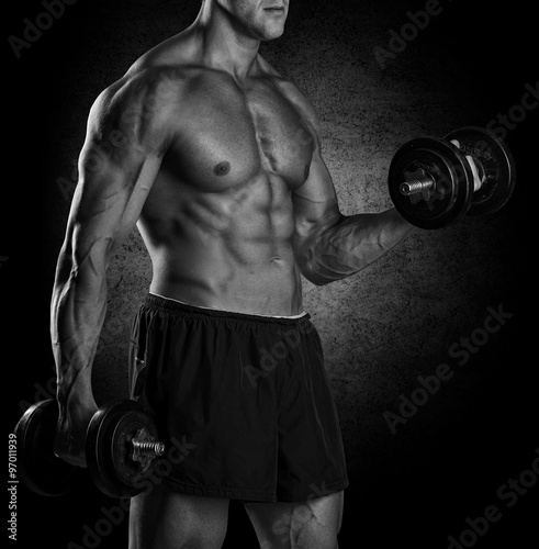 Closeup of a muscular young man lifting weights