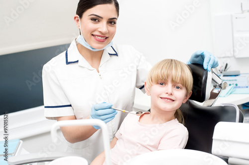 Professional dentist posing with girl child