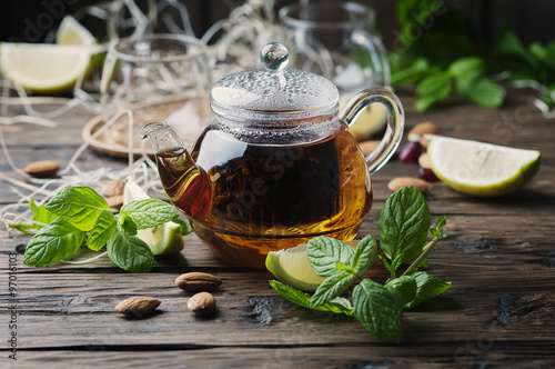 Hot black tea with lemon and mint on the wooden table