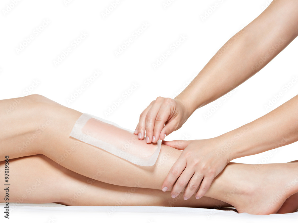 woman depilating legs by waxing