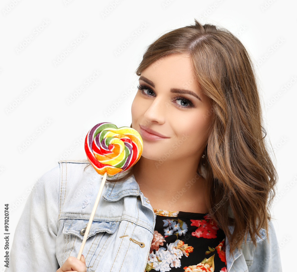 Laughing girl holding big lollipop.Blue background.