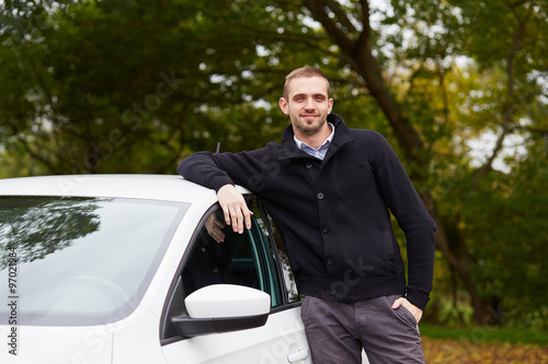 Man standing leaning on car
