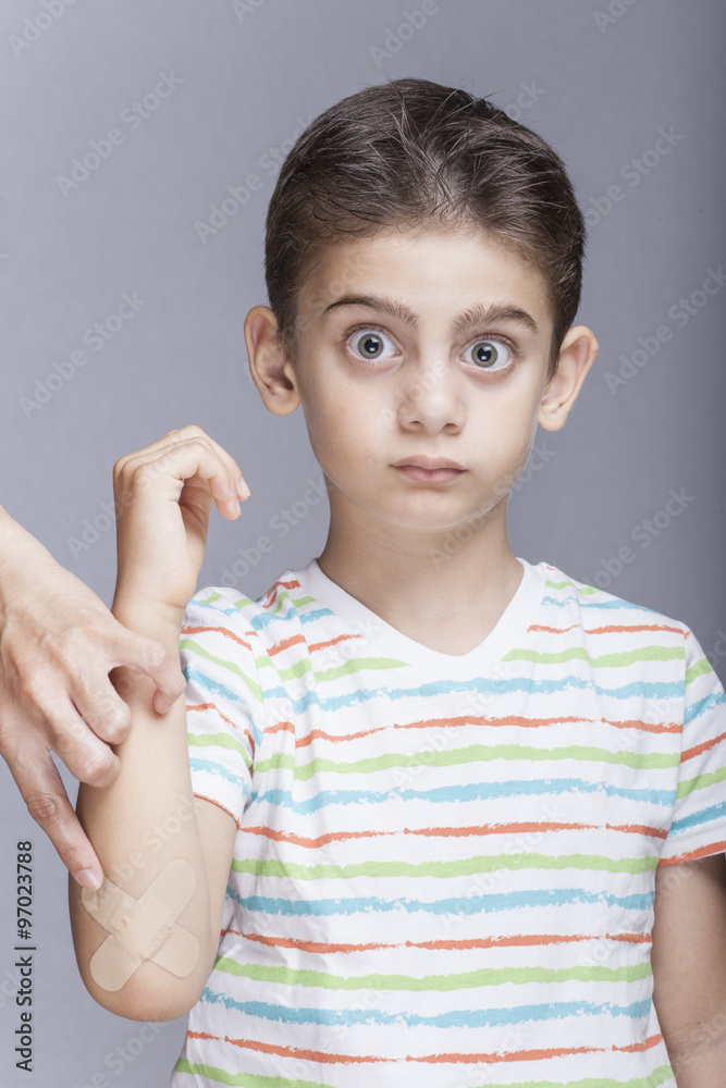 Cute little boy reacts while receiving treatment for a bruised elbow Cute little boy reacts while receiving treatment for a bruised elbow
