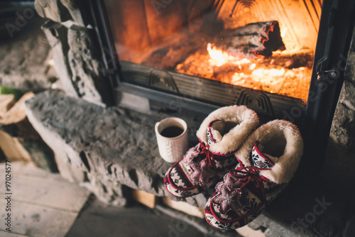 Fotografi Christmas comfortable slippers by the warm cozy fireplace