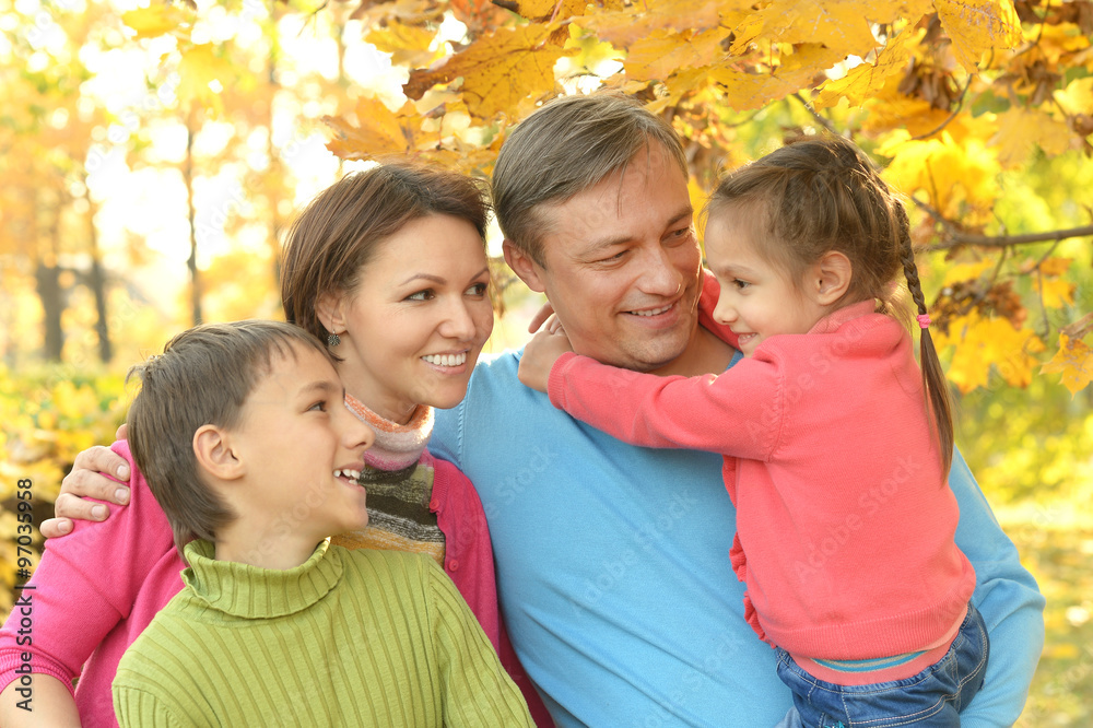 Family relaxing in autumn park