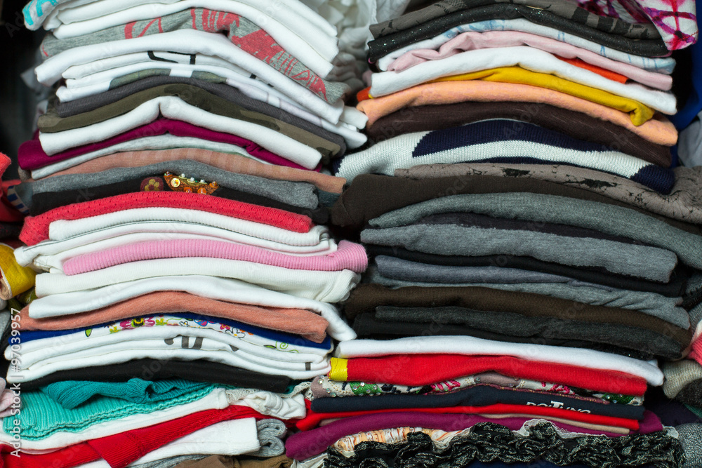 Women's T-shirts are piled up in a closet. Wearing these colorful shirts can make the day cheerful.