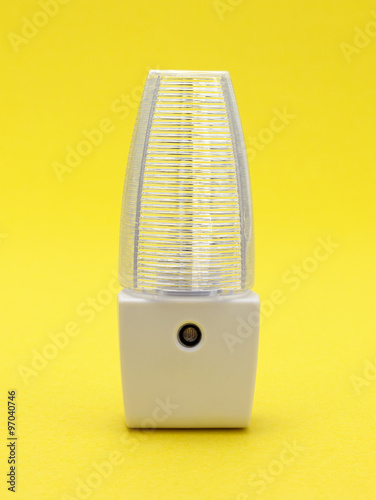 Generic LED night light on a yellow background.