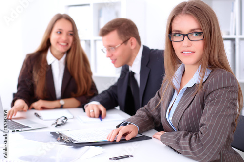 A group of business people at a meeting on the background of office. Focus on a beautiful brunette