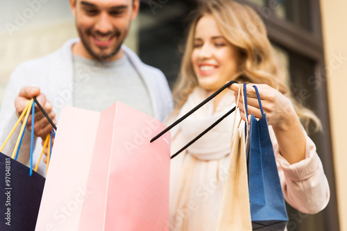 close up of couple with shopping bags on street