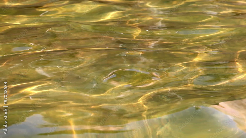 Small waves on a water surface as background in golden tone Small waves on a water surface as background in golden tone