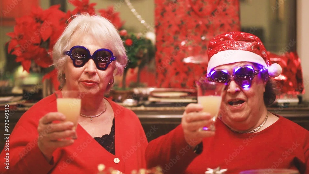 senior ladies with funny sunglasses toasting for christmas time