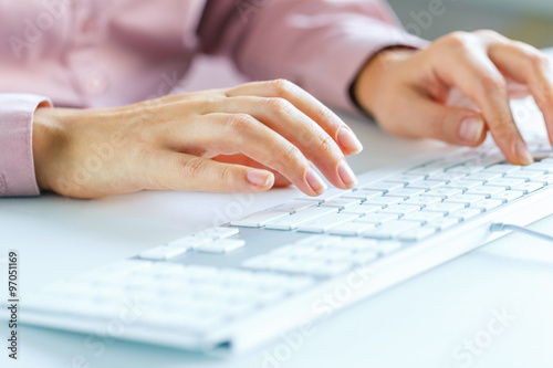 Woman office worker typing on the keyboard