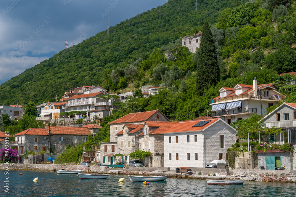 Lepetane old town under the mountains.Eembankment view from water.