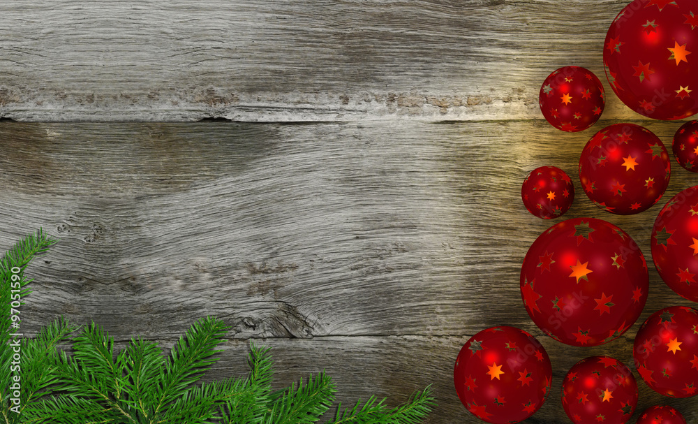 Christbaumkugeln mit Sternen und Tannengrün auf Holz hintergrund