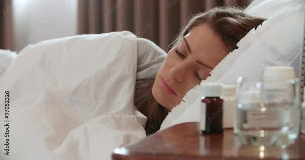 Woman Taking Medication From Containers On Bedside Table Woman Taking Medication From Containers On Bedside Table
