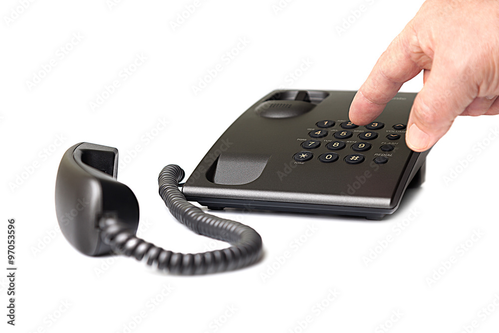 Black push-button telephone and the hand that dials the number. Black push-button telephone and the hand that dials the number.