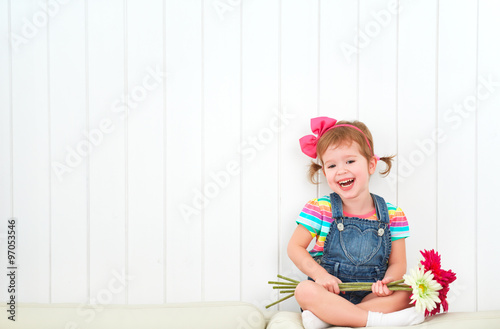 Happy child little girl with bouquet of gerbera flowers in empt