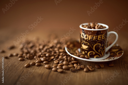 Coffee cup with beans on wooden background