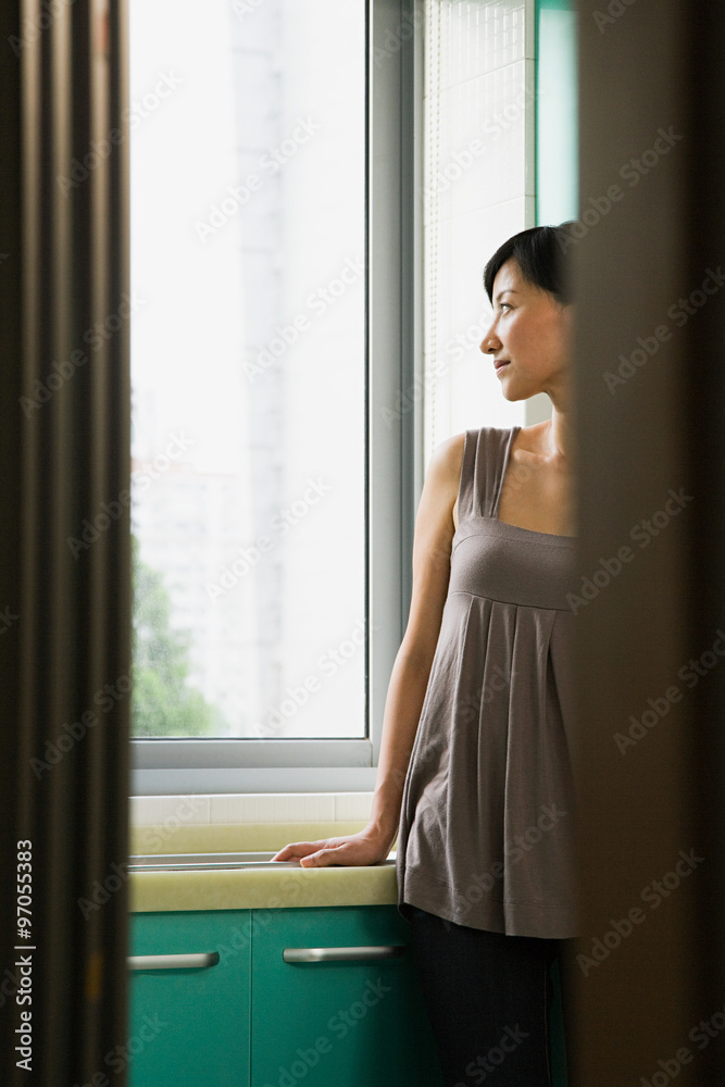 Young woman looking out of a window