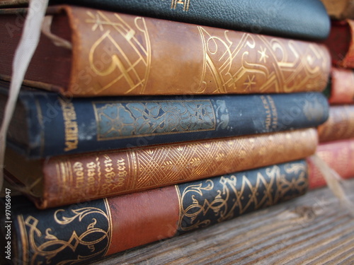 Pile of antique books on a wooden board.