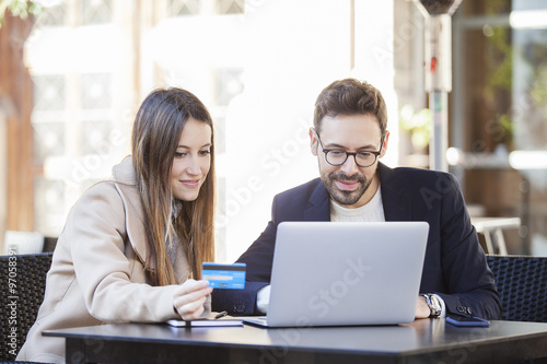 Online shopping. Happy couple using credit card to internet shop on-line. Young couple with Laptop Computer and Credit Card buying online.